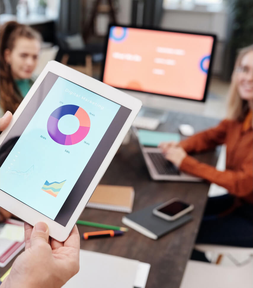 Réunion d'affaires avec graphiques sur tablette.