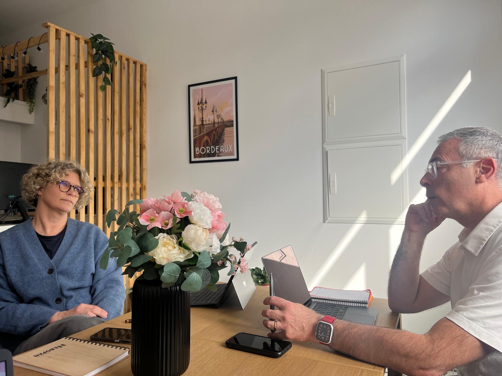 Deux personnes discutant dans un bureau moderne.