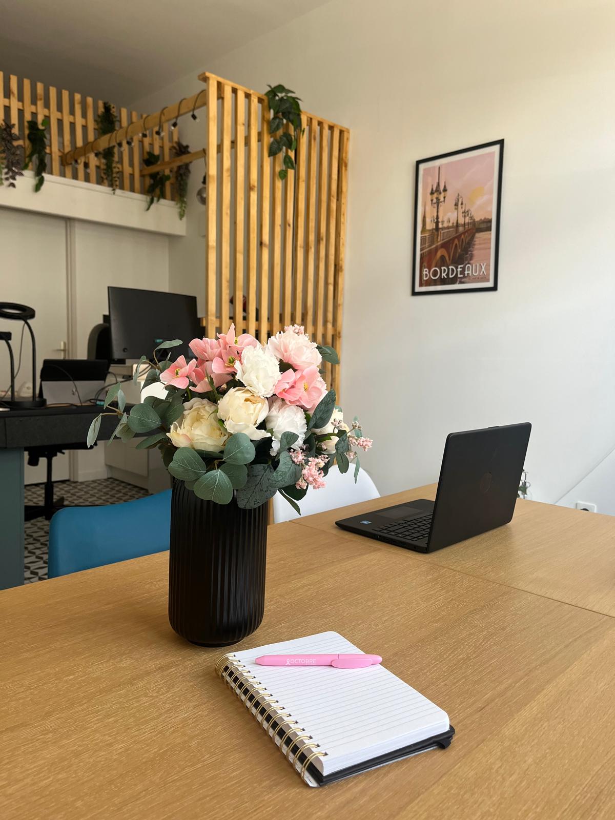 Bureau moderne avec bouquet de fleurs roses.
