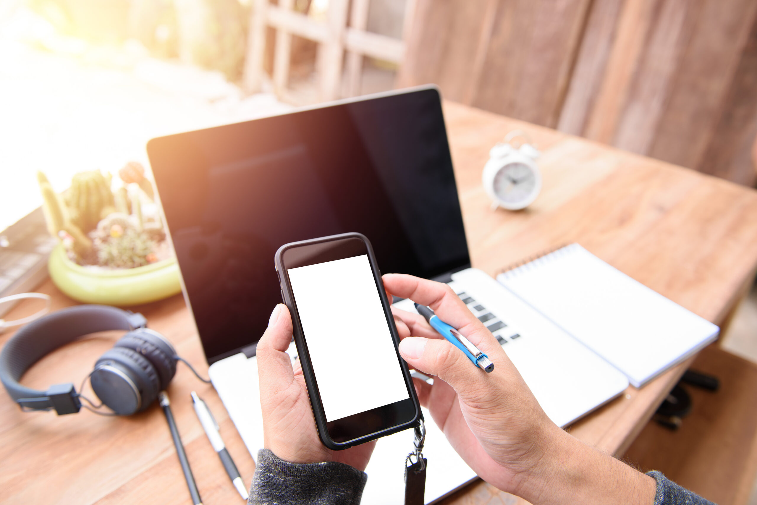 Personne utilisant un smartphone et un ordinateur portable